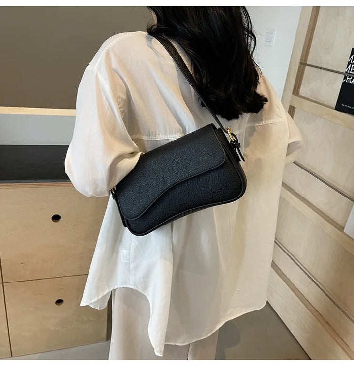 Petit sac noir chic pour femme, en simili-cuir, design moderne pour accessoiriser votre tenue élégante.