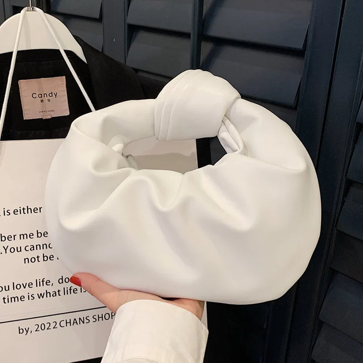 Sac à main rond féminin en cuir synthétique, design élégant et compact, idéal pour compléter une tenue chic.