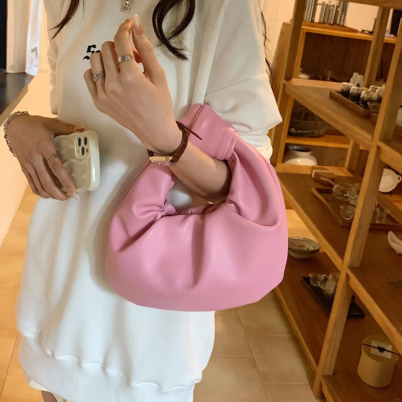 Sac rond en cuir synthétique, couleur unie, idéal comme sac à main compact ou accessoire de mode pour femme.