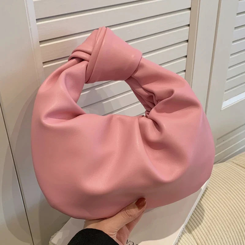 Sac à main rond noir élégant en cuir synthétique, petit et compact, idéal pour un porté main féminin.