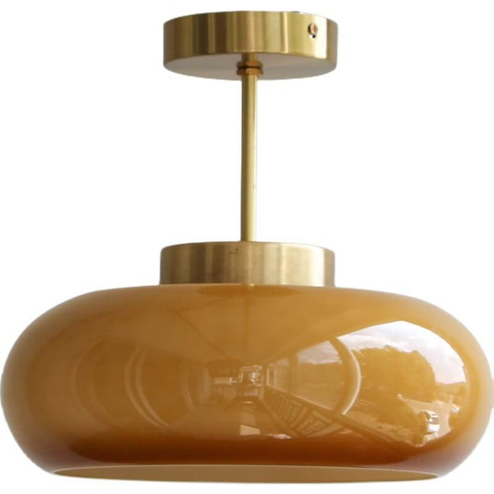 Plafonnier vintage en laiton avec dôme en verre jaune, design rétro élégant offrant une ambiance chaleureuse et accueillante.