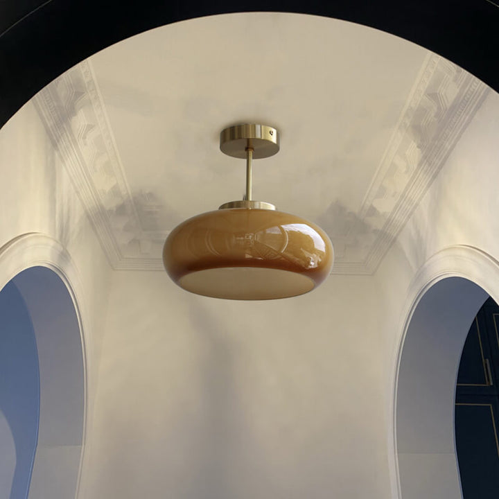 Plafonnier vintage en laiton avec dôme en verre jaune, design rétro élégant offrant une ambiance chaleureuse et accueillante.