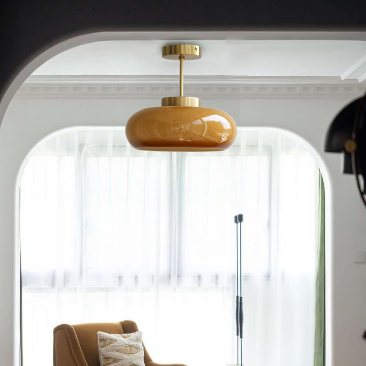 Plafonnier vintage en laiton avec dôme en verre jaune, design rétro élégant offrant une ambiance chaleureuse et accueillante.