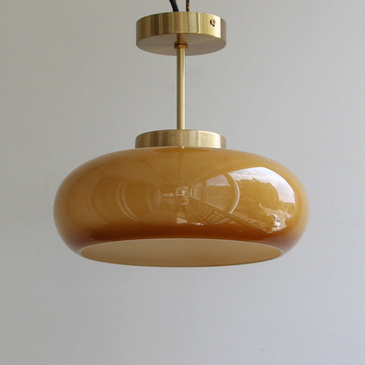 Plafonnier vintage en laiton avec dôme en verre jaune, design rétro élégant offrant une ambiance chaleureuse et accueillante.
