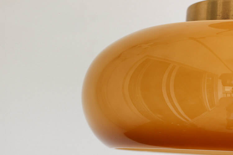 Plafonnier vintage en laiton avec dôme en verre jaune, design rétro élégant offrant une ambiance chaleureuse et accueillante.