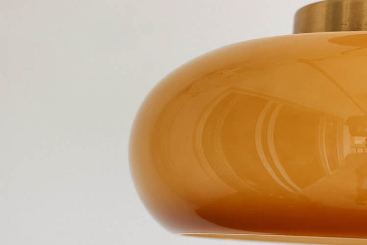Plafonnier vintage en laiton avec dôme en verre jaune, design rétro élégant offrant une ambiance chaleureuse et accueillante.