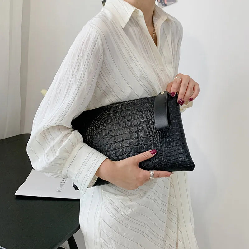 Sac à main pochette noir en similicuir, idéal pour les soirées formelles et événements.