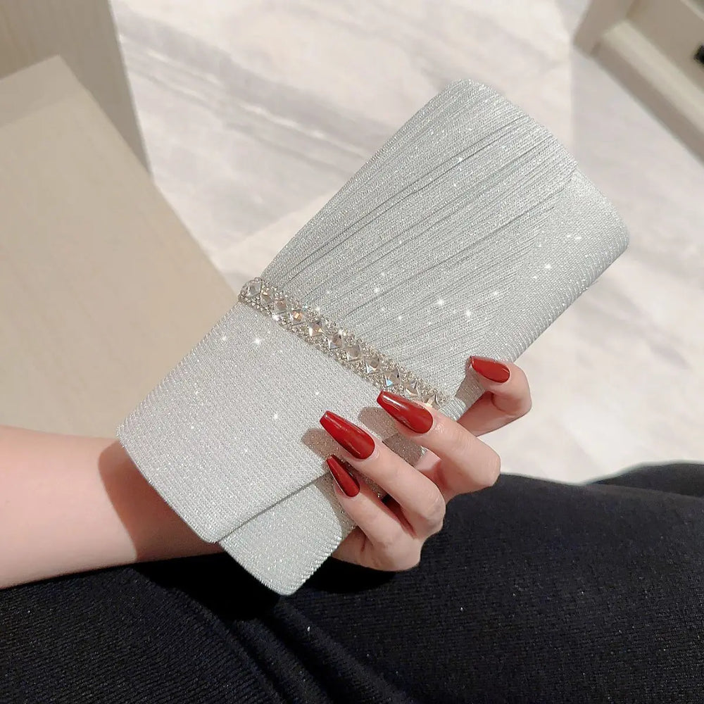 Sac de soirée clutch argenté brillant pour femme, orné de strass, idéal pour événement chic.