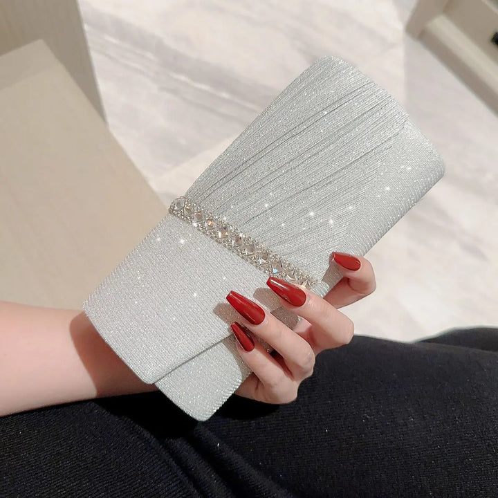 Sac de soirée clutch argenté brillant pour femme, orné de strass, idéal pour événement chic.