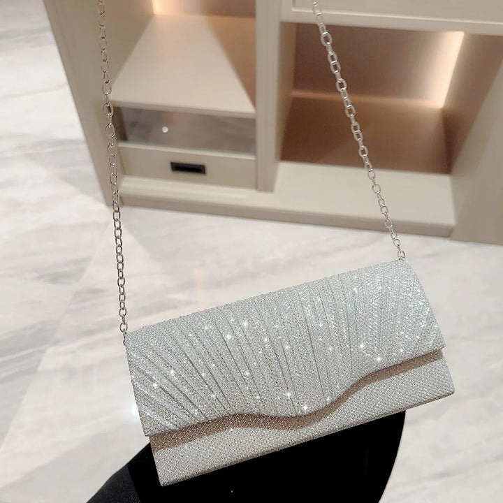 Accessoire femme: pochette scintillante argentée avec motif strass, parfaite pour une soirée habillée.