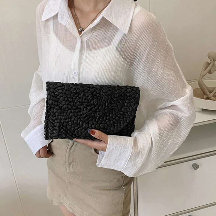 Pochette femme naturelle en paille tressée, idéale pour un look d'été élégant.