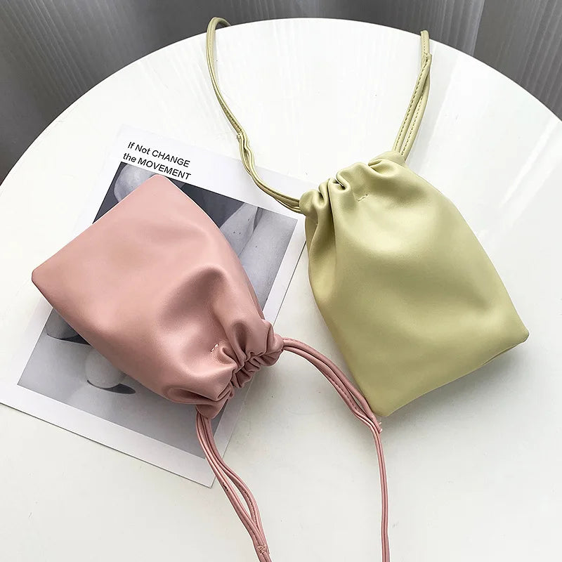 Femme portant une pochette téléphone bandoulière, mains libres, style chic pour la ville.
