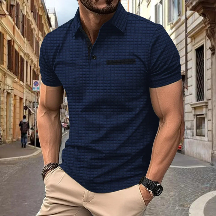 Homme portant un polo décontracté gris avec jean, style intemporel pour un look quotidien.