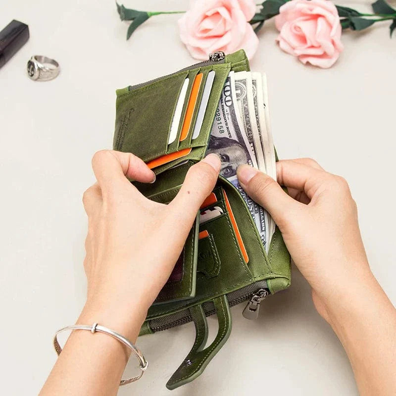 Gros plan sur la texture du cuir véritable du portefeuille compact femme, couleur verte.