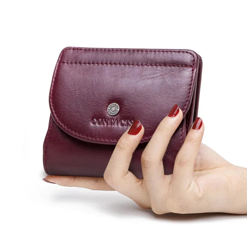 Portefeuille compact chic pour femme en cuir bleu marine, posé à côté de clés, soulignant sa petite taille pratique.