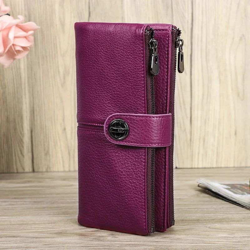 Gros plan d'un portefeuille femme en cuir rouge, montrant la texture raffinée du cuir et les surpiqûres.