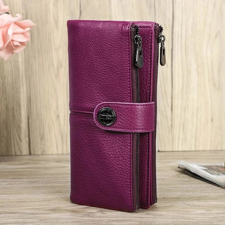 Gros plan d'un portefeuille femme en cuir rouge, montrant la texture raffinée du cuir et les surpiqûres.