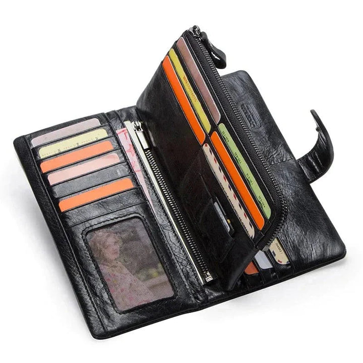 Portefeuille homme en cuir brun, plié en trois volets, tenant dans la main d'un homme, montrant sa taille compacte.