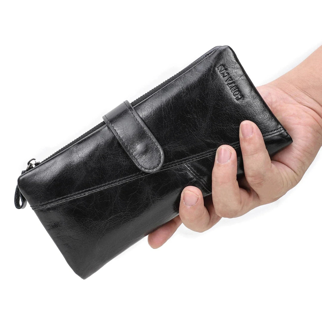Accessoire essentiel : un portefeuille homme en cuir marron, trois volets, présenté avec des clés et un téléphone.
