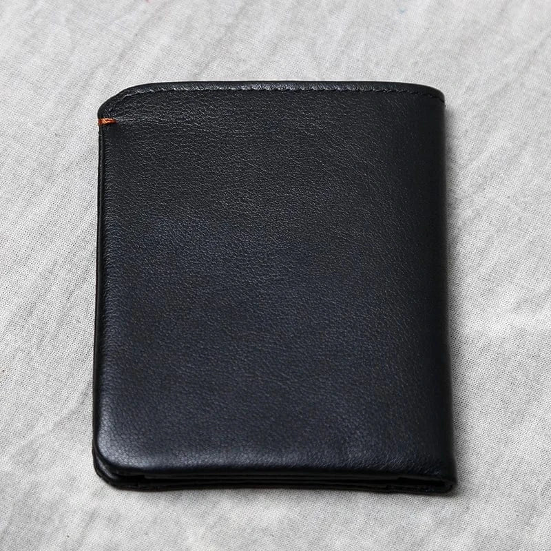 Accessoire vintage: portefeuille en cuir véritable compact pour hommes, tenue en main, texture visible.