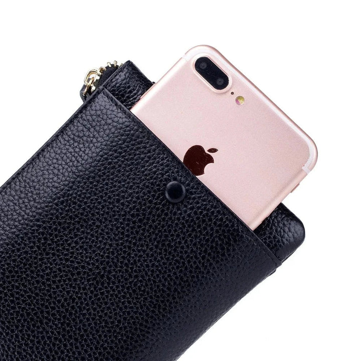 Vue ouverte d'un portefeuille long en cuir rose, montrant les fentes pour cartes et poches zippées.