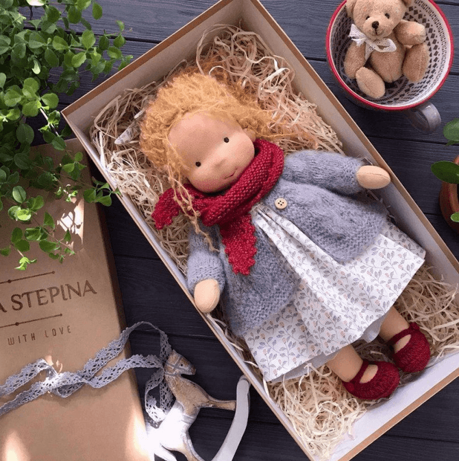 Gros plan d'une poupée Waldorf. Détails artisanaux et matières naturelles. Un cadeau précieux pour enfant.