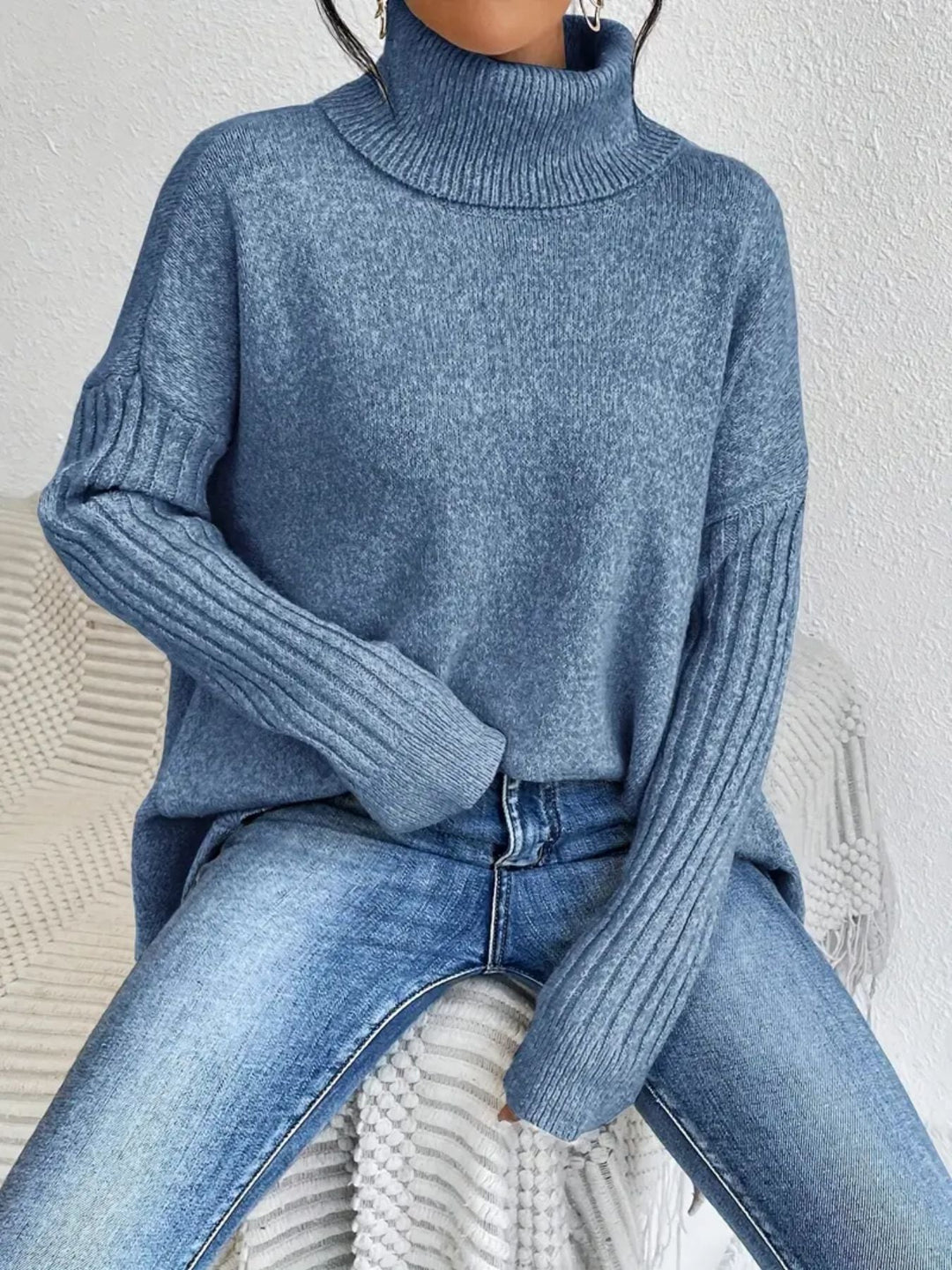 Pull femme à manches longues, col roulé et ourlet asymétrique, pour un look moderne décontracté.