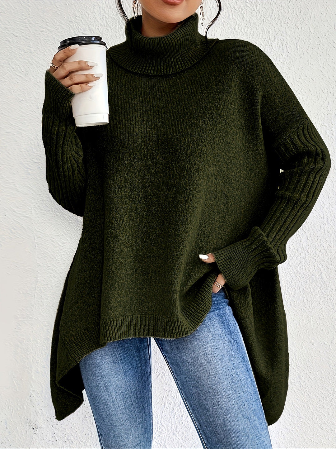 Pull femme moderne, col roulé et ourlet irrégulier, créant un style unique et chic pour l'hiver.