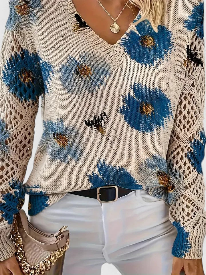 Détail d'un pull femme tricoté à col V, motif floral délicat, manches longues élégantes.