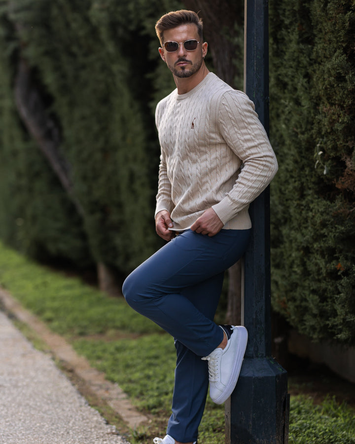 Détail rapproché du pull homme à torsades complexes, texture riche et artisanale.