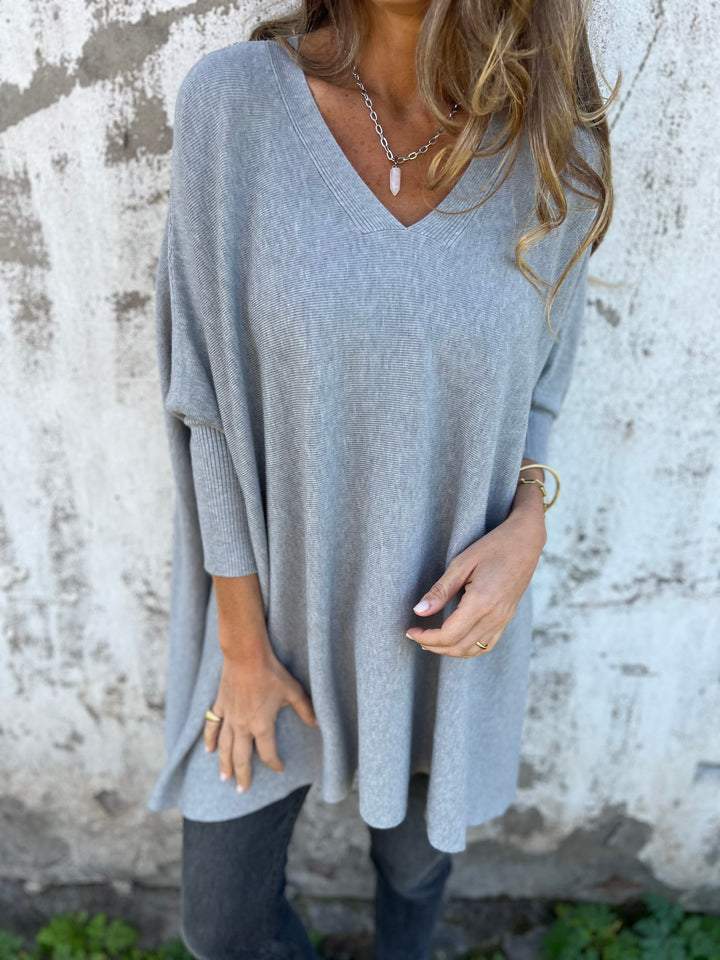 Pull tricoté noir oversize femme, col V et manches longues. Un vêtement chic et doux pour l'hiver élégant.