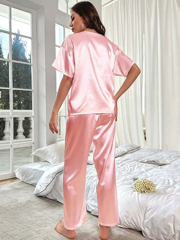 Pyjama en satin ultra-doux, coupe élégante avec haut à poche et pantalon large, couleur pastel chic, confort luxueux.