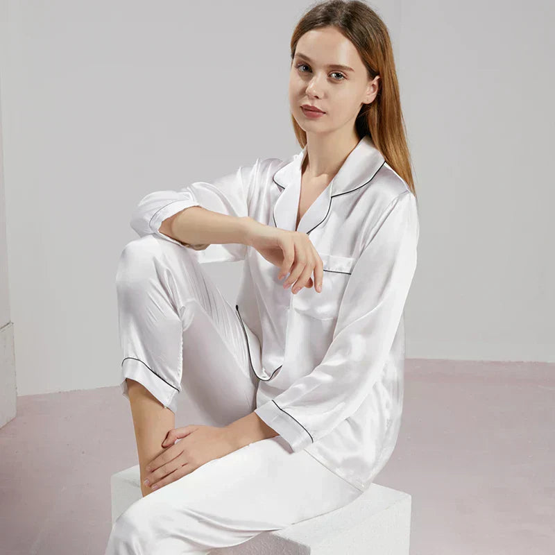 Pyjama femme en satin soyeux et manches longues, joliment plié, prêt à être offert comme cadeau élégant et doux.