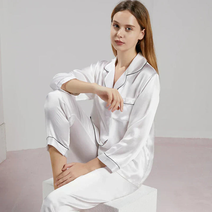 Pyjama femme en satin soyeux et manches longues, joliment plié, prêt à être offert comme cadeau élégant et doux.