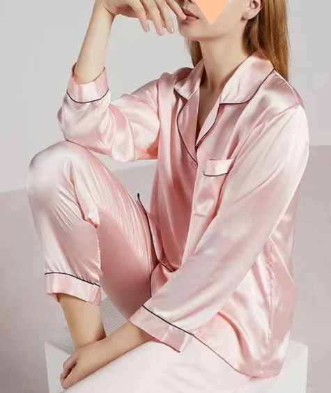 Gros plan sur la texture brillante du satin du pyjama femme, manches longues, pour une sensation de douceur.