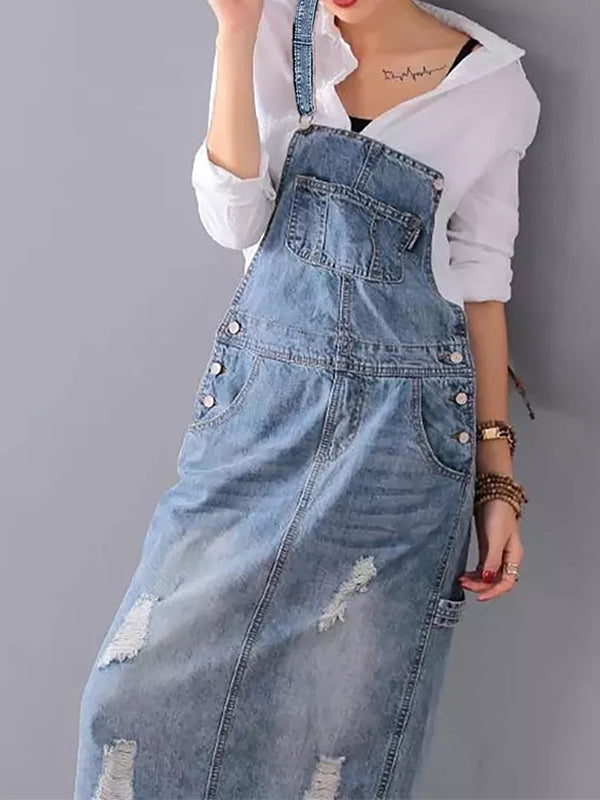 Modèle portant une robe à bavette en jean distressed, look casual moderne, mode féminine actuelle.