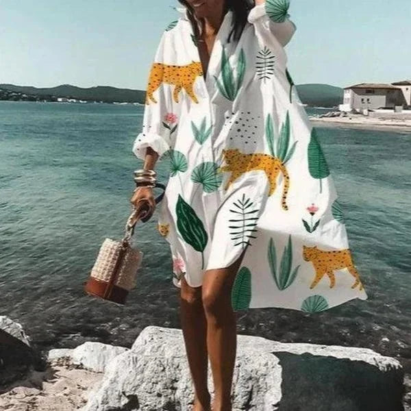 Élégante robe d'été blanche, coupe chemise fluide, longueur midi, idéale pour un look frais et chic.