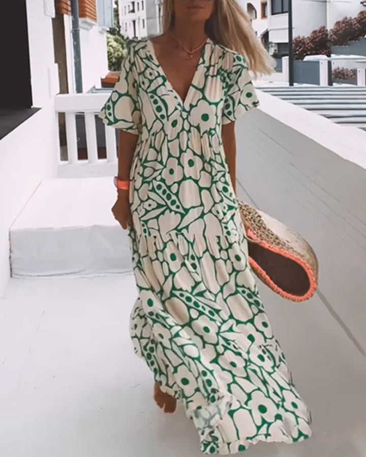 Femme portant robe d'été décontractée à imprimé, col en V, style estival polyvalent pour plage ou ville.