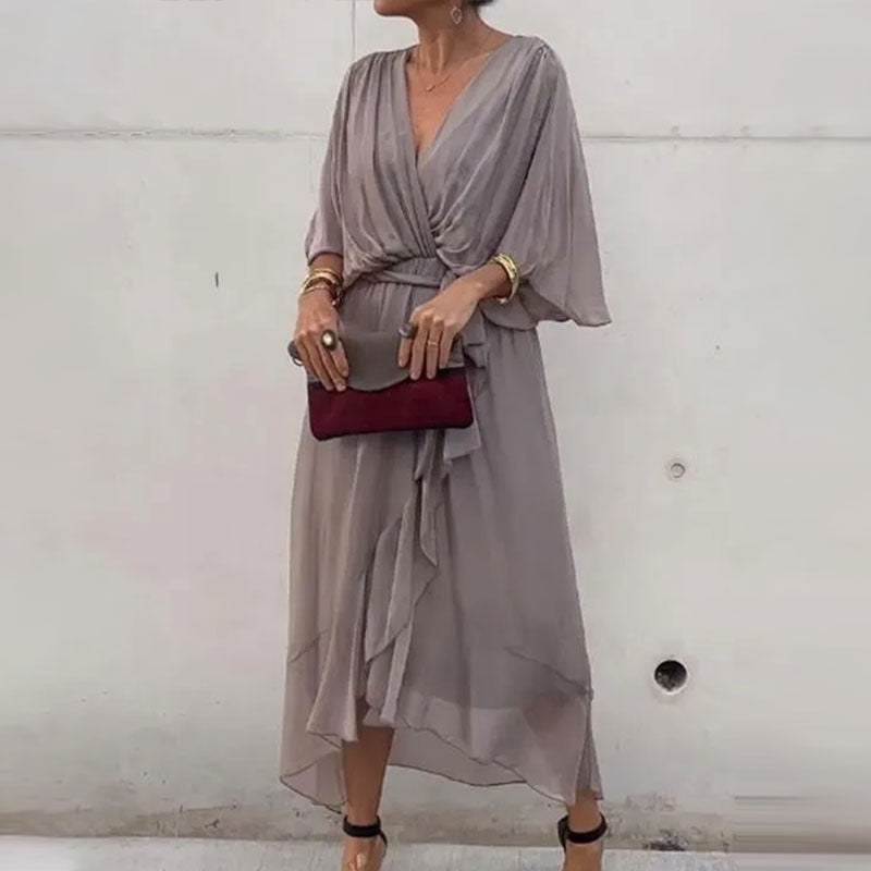 Femme portant une robe d'été midi fluide et élégante, col V, pour un look estival décontracté chic.