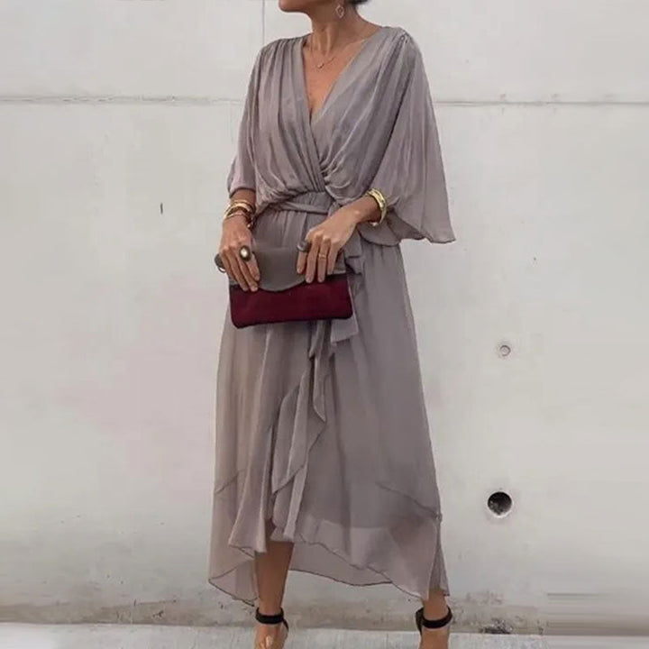 Femme portant une robe d'été midi fluide et élégante, col V, pour un look estival décontracté chic.