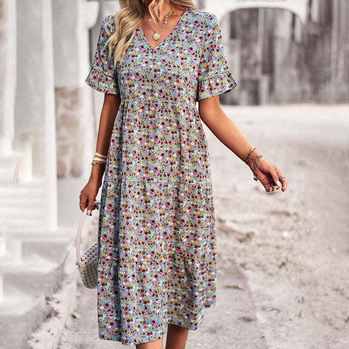 "Robe d'été fleurie vivante, tissu léger, imprimé floral vibrant, couleur abricot, parfaite pour sorties ensoleillées."