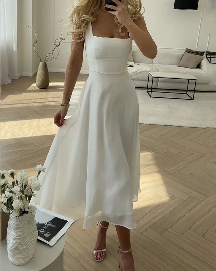 Robe élégante en soie, col carré, coupe classique.  Disponible en S, M, L, XL.