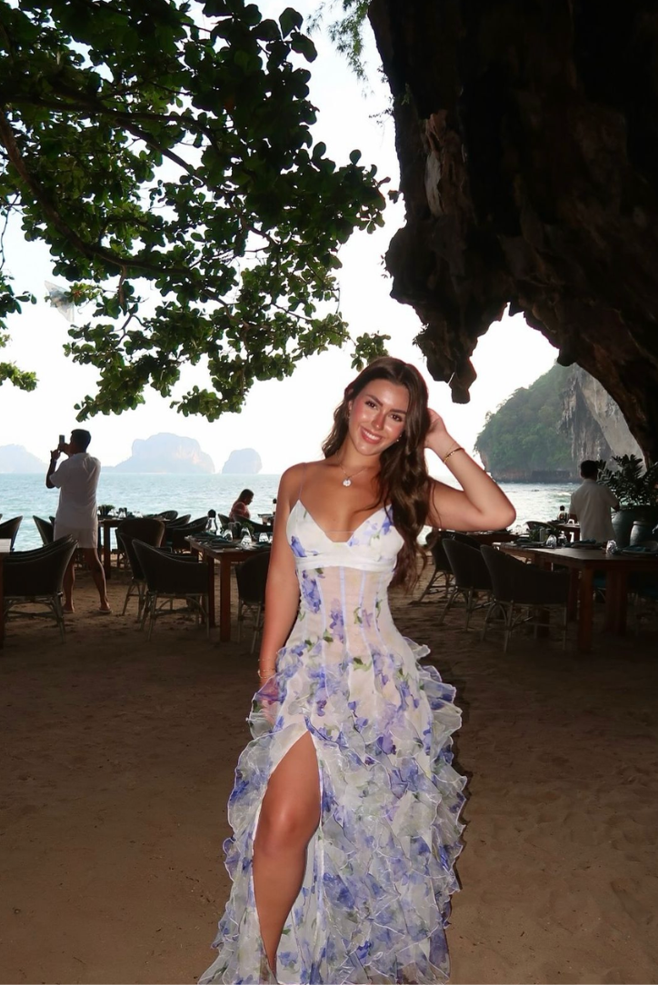 "Robe longue bleue féminine à motifs floraux et volants, bretelles fines, vue de face, style romantique et fluide."