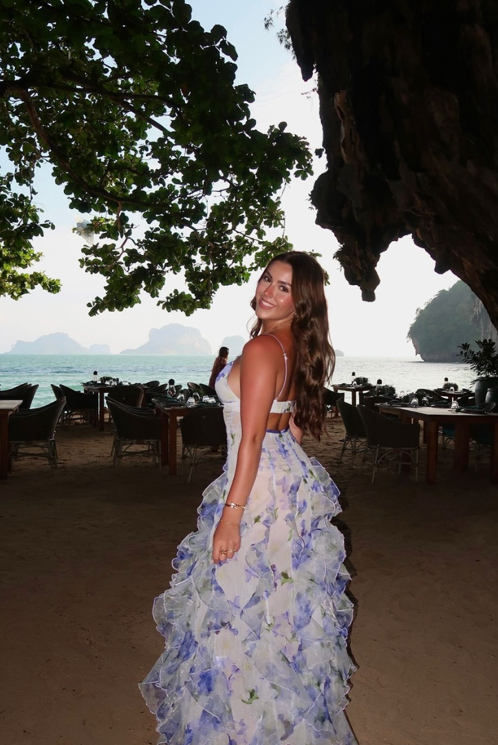 "Robe longue bleue féminine à motifs floraux et volants, bretelles fines, vue de face, style romantique et fluide."