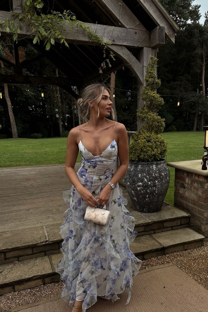 "Robe longue bleue féminine à motifs floraux et volants, bretelles fines, vue de face, style romantique et fluide."