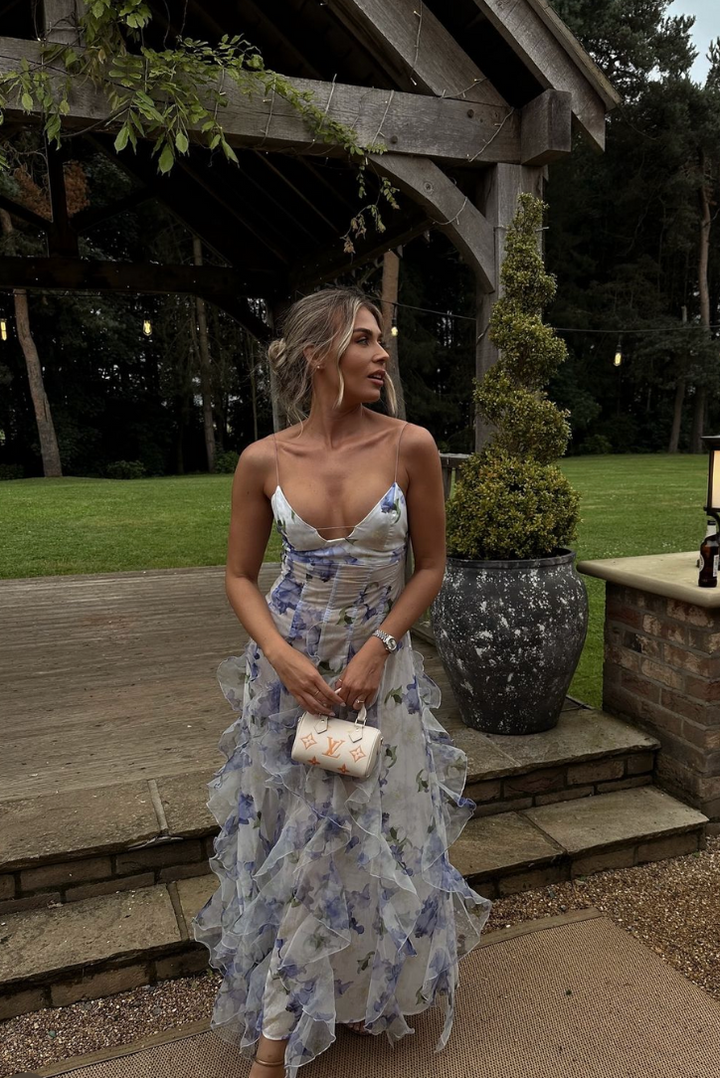 "Robe longue bleue féminine à motifs floraux et volants, bretelles fines, vue de face, style romantique et fluide."