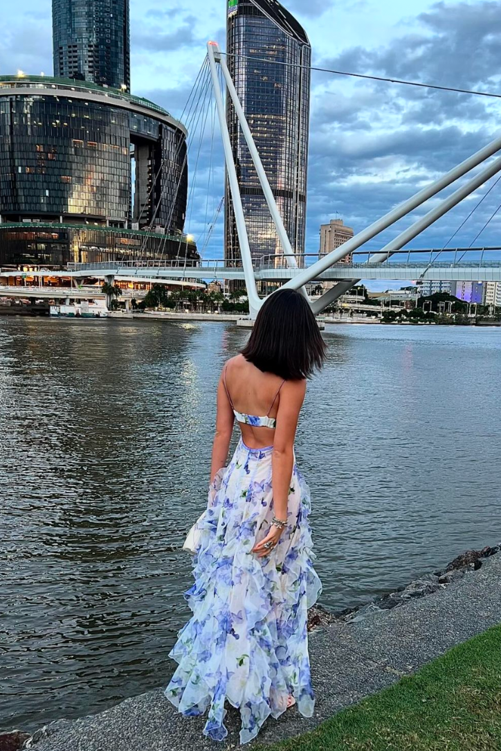 "Robe longue bleue féminine à motifs floraux et volants, bretelles fines, vue de face, style romantique et fluide."