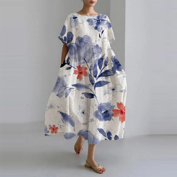 "Robe longue en lin beige clair avec motif floral coloré, coupe ample, manches courtes pour confort estival"