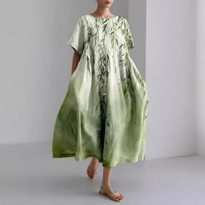 "Robe longue en lin beige clair avec motif floral coloré, coupe ample, manches courtes pour confort estival"