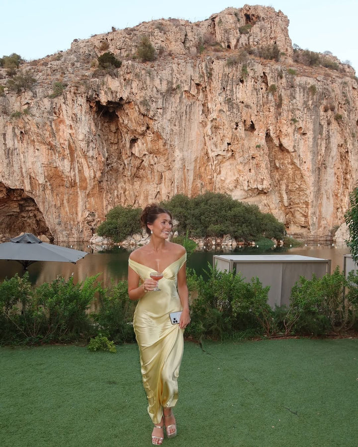 "Robe longue en satin champagne, dos nu, vue de face, silhouette fluide pour soirée élégante."